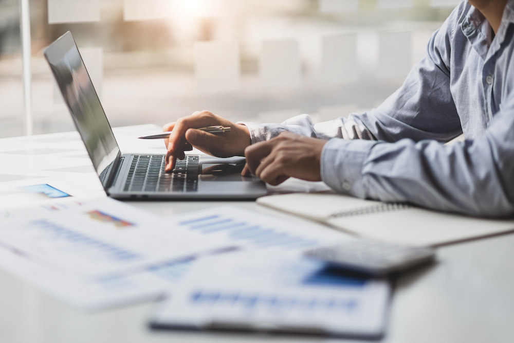 Modern business accountants are using laptops to check financial transactions using laptop software